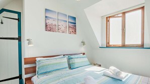 A bedroom with a bed, pillows, a window, and a wall-mounted picture. - 4 Bed in Pevensey Bay (oc-bt069) (Pevensey Bay)
