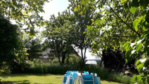 A grassy outdoor area with several blue chairs arranged in a circle. - Le gîte du "Grand Reu" - Gîte Anna (Corancy)