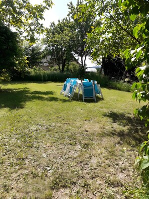 A grassy outdoor area with several blue chairs arranged in a circle. - Le gîte du "Grand Reu" - Gîte Anna (Corancy)
