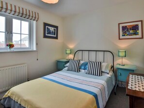 A bedroom with a bed, two bedside tables, a window with curtains, a radiator, and two framed pictures on the wall. - 2 Bed in Camber (oc-bt084) (Camber)