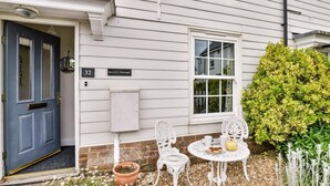 A white house with a blue door, a mailbox, and a number 32 sign. - 2 Bed in Camber (oc-bt084) (Camber)