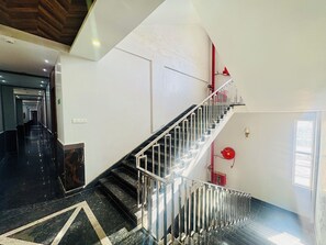 Un intérieur moderne avec un escalier, un couloir et une porte.