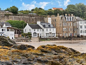 A coastal town with stone buildings, a beach, and rocky outcrops. - 1 Bed in Burntisland (oc-47388) (Kinghorn)