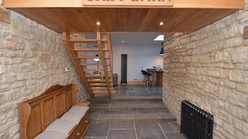 A staircase leading to a loft area with a wooden bench and a sign reading 'GRIPP BARN'.