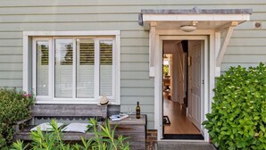 A house with a front porch, a bench, a door, and a small garden area. - 4 Bed in Rye- (oc-bt104) (Rye)