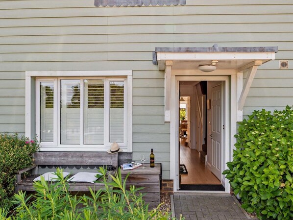 A house with a front porch, a bench, a door, and a small garden area. - 4 Bed in Rye- (oc-bt104) (Rye)
