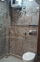Ein Badezimmer mit Toilette, Dusche und Marmorwand.
