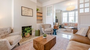 Ein Wohnzimmer mit Kamin, Sofas, einem Couchtisch und einem Bücherregal.