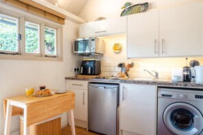 A compact kitchen with a microwave, coffee maker, and washing machine. - 1 Bed in Battle (oc-bt112) (Battle)
