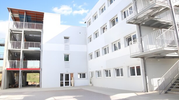 A multi-story building with external staircases and balconies. - Room with Shared Terrace and Wi-Fi, 10 Minutes from the Beach (Mudaison)