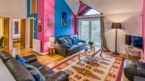 Ein Wohnzimmer mit einer Couch, einem Couchtisch und einem Fernseher.