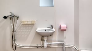 Ein Badezimmer mit Waschbecken, Spiegel, Dusche und Handtuchspender.