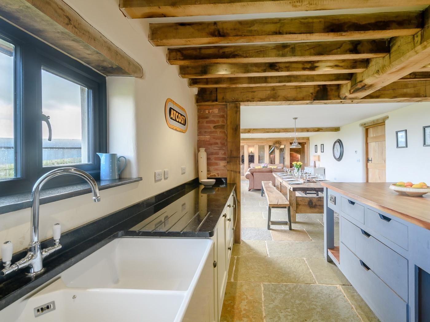 A kitchen with a sink, countertop, and a sign that reads 'AT COST.'