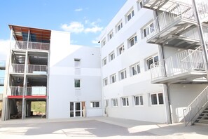 Ein mehrstöckiges Gebäude mit Außenstairn und Balkonen.