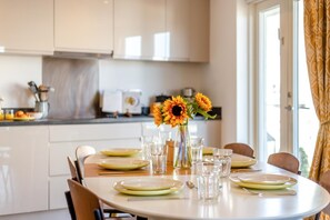 A dining table set with plates, glasses, and a vase with sunflowers. - 2 Bed in Bournemouth (oc-48516) (Bournemouth)