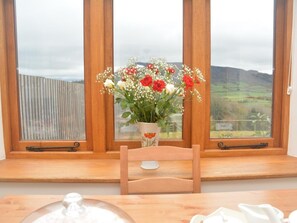 A wooden chair in front of a window with a view of a rural landscape. - 1 Bed in Abergavenny (oc-47884) (Pantygelli)