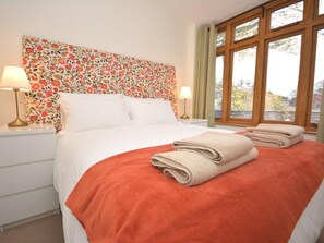 A hotel room with a bed, two bedside lamps, a window with curtains, and a view of the outside. - 1 Bed in Abergavenny (oc-47884) (Pantygelli)