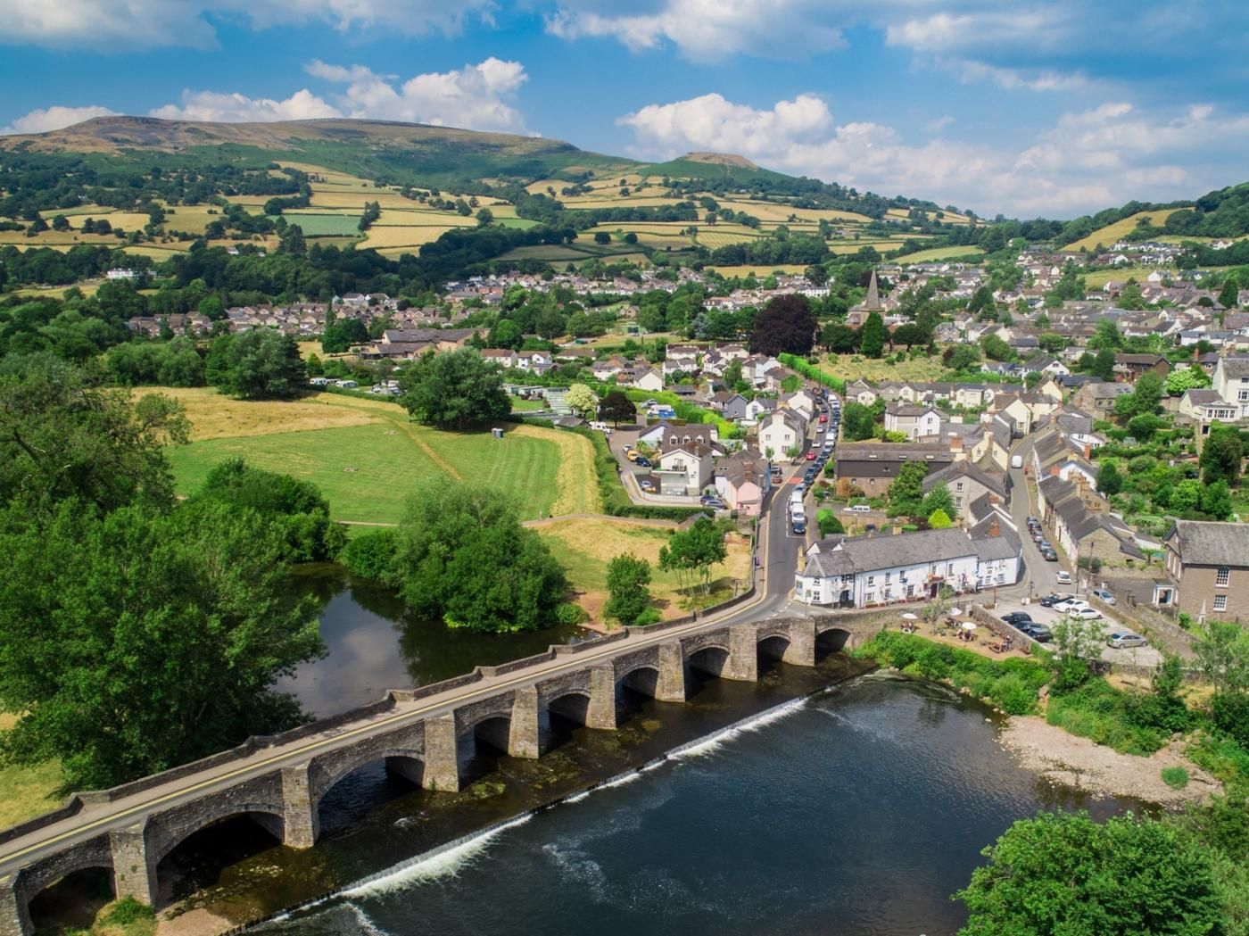 A river flowing under a bridge with a town in the background.