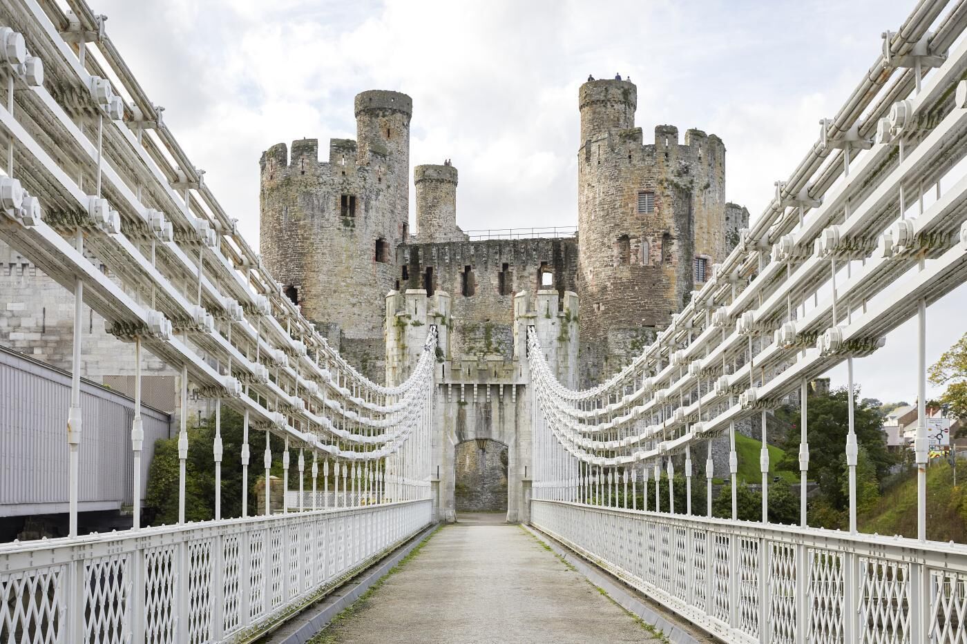 A bridge leading to a castle with multiple towers and a central entrance.