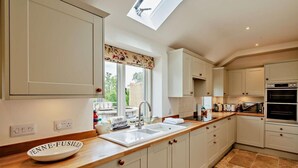 A kitchen with a skylight, a sink, a double oven, and a wooden countertop. - 3 Bed in Shaftesbury (oc-48804) (East Melbury)