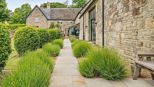 A stone building with a pathway leading to a house. - 3 Bed in Shaftesbury (oc-48804) (East Melbury)