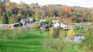 Uma vila rural com casas, um lago e folhagem de outono.
