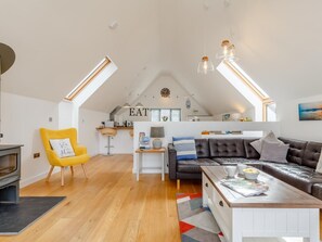 Ein geräumiger Lofts mit Küche, Essbereich und einer gemütlichen Sitzecke mit Kamin.