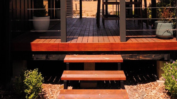 A covered outdoor seating area with wooden benches and a pergola structure.