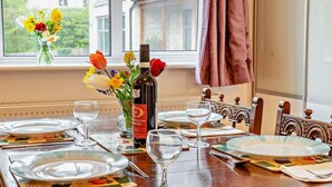 A dining table set with plates, glasses, and a bottle of wine. - 2 Bed in Cheltenham (oc-49336) (Woodmancote)