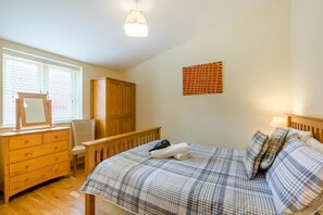 A bedroom with a bed, dresser, chair, wardrobe, and a wall-mounted artwork. - 2 Bed in North Walsham (oc-49719) (Worstead)