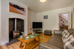 A living room with a fireplace, a television, a sofa, and a chess table. - 3 Bed in Dorchester (oc-49005) (Owermoigne)