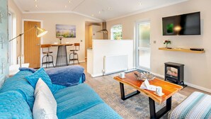 Een moderne woonkamer met een bank, een salontafel, een televisie en een open haard.