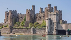 A historic castle with multiple towers and a moat. - 2 Bed in Conwy (oc-50284) (Ty'n-y-groes)
