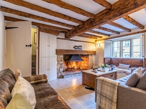 A cozy living room with a stone fireplace, wooden beams, and comfortable seating. - 3 Bed in Cheltenham (oc-49965) (Lower Swell)