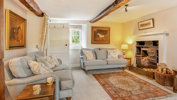 A cozy living room with two sofas, a coffee table, a fireplace, and a rug. - 4 Bed in Hawkshead (oc-llh02) (Near Sawrey)