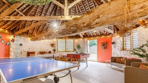 A spacious indoor area with a ping pong table, seating, and a rustic wooden ceiling. - 4 Bed in Umberleigh (oc-50154) (Burrington)