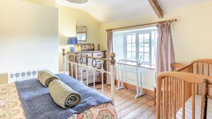 A room with a bed, a wooden crib, a dresser, a mirror, and a window with curtains. - 3 Bed in Dorchester (oc-50290) (Hilfield)