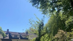 Una casa con jardín, mobiliario exterior y cielo despejado.
