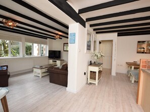 A modern living room with a sofa, TV, and a sign that reads 'A WALK ON THE BEACH IS GOOD FOR THE SOUL.' - 2 Bed in St. Agnes (oc-50085) (Saint Agnes)