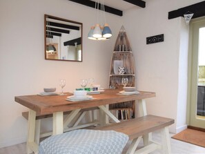 A dining area with a wooden table, benches, hanging pendant lights, a bookshelf, and a mirror. - 2 Bed in St. Agnes (oc-50085) (Saint Agnes)