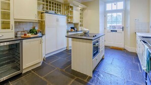 A kitchen with white cabinetry, a central island, and a built-in oven. - 4 Bed in Hawkshead (oc-llh03) (Hawkshead)