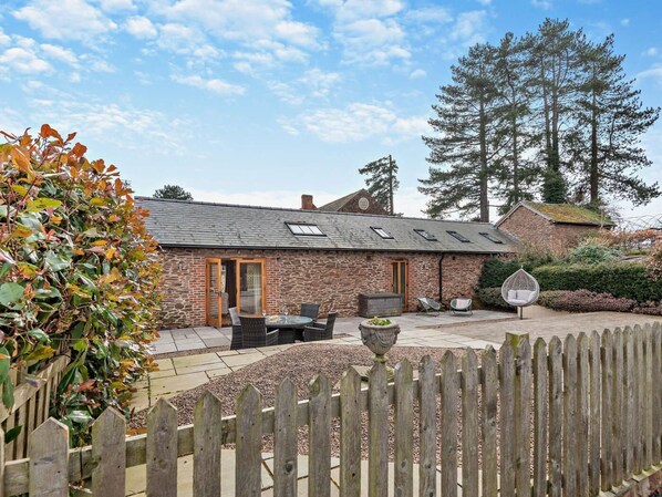A stone building with a patio area, outdoor seating, and a wooden fence. - 2 Bed in Bromyard (oc-50518) (Pencombe)