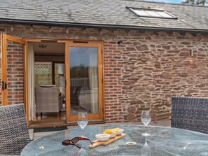 A glass table with a bowl of chips, two wine glasses, and a pair of sunglasses. - 2 Bed in Bromyard (oc-50518) (Pencombe)