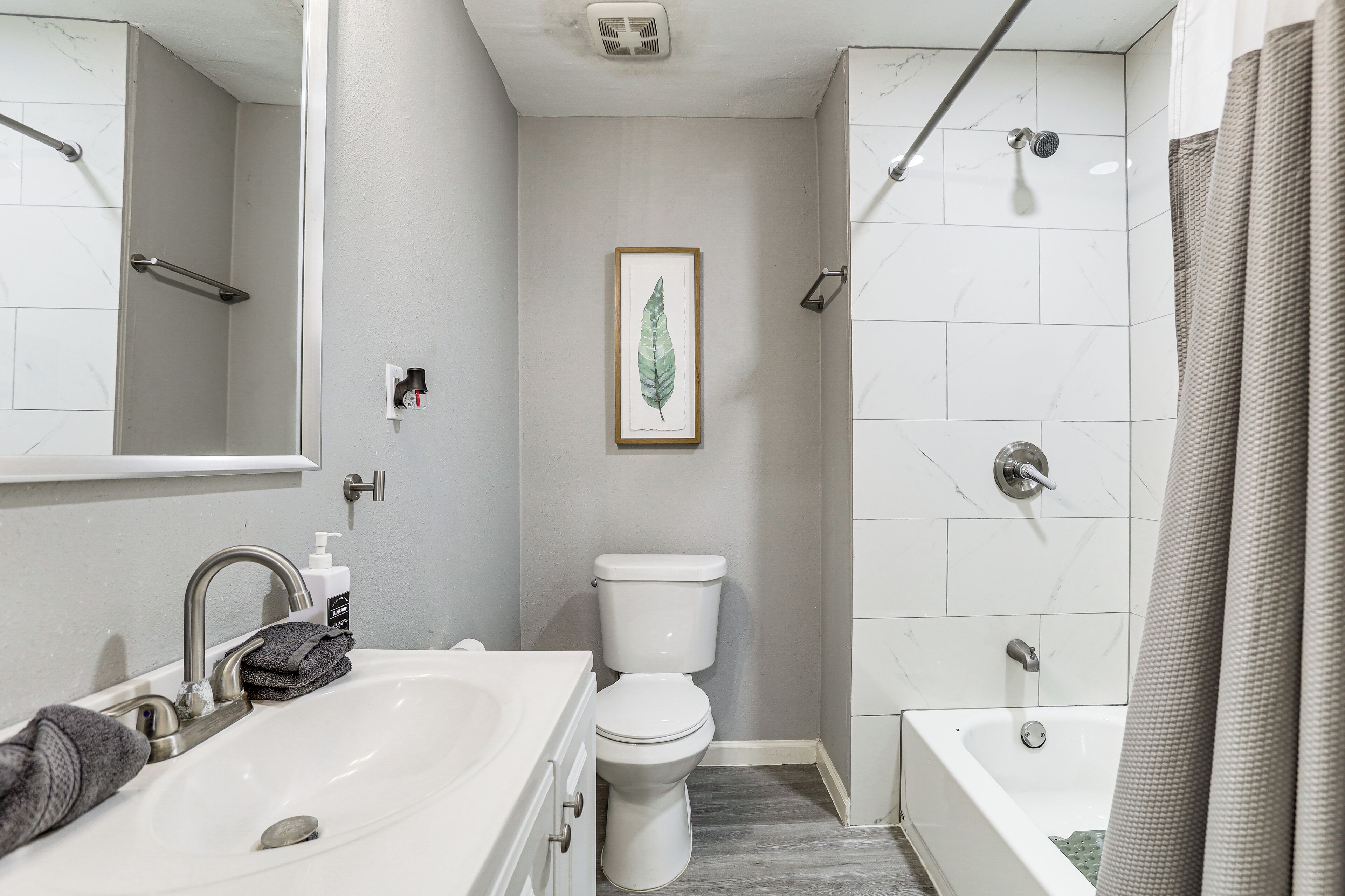 Une salle de bain comprenant un lavabo, des toilettes et un espace douche.
