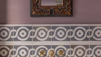 A bathroom with a vanity, mirror, and decorative wall sconces.