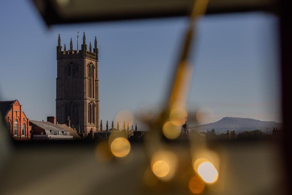 A church tower with a steeply pitched roof and a large bell tower.