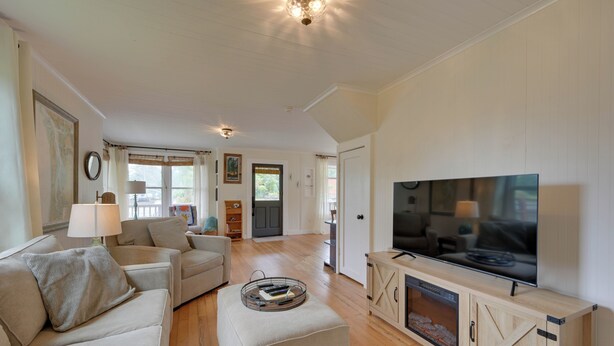 A living room with a television, sofas, and a fireplace.