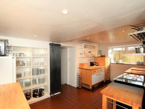 A kitchen with a central island, white cabinetry, and a window with a view. - 7 Bed in Hawkshead (oc-llh47) (Hawkshead)