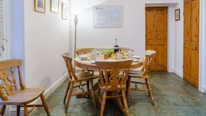Un coin repas avec une table ronde, des chaises en bois et des aliments pour le petit-déjeuner.