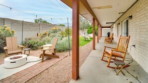 A covered patio with outdoor seating, a fire pit, and a brick pathway. - Chic 5br, Yard, Mtn Views, Games 4 fun Family Time (Albuquerque)